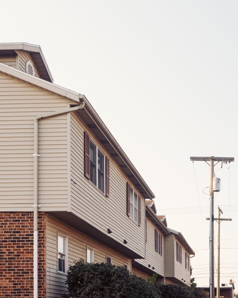 Attached suburban homes with brick and beige siding exteriors in a quiet residential neighborhood